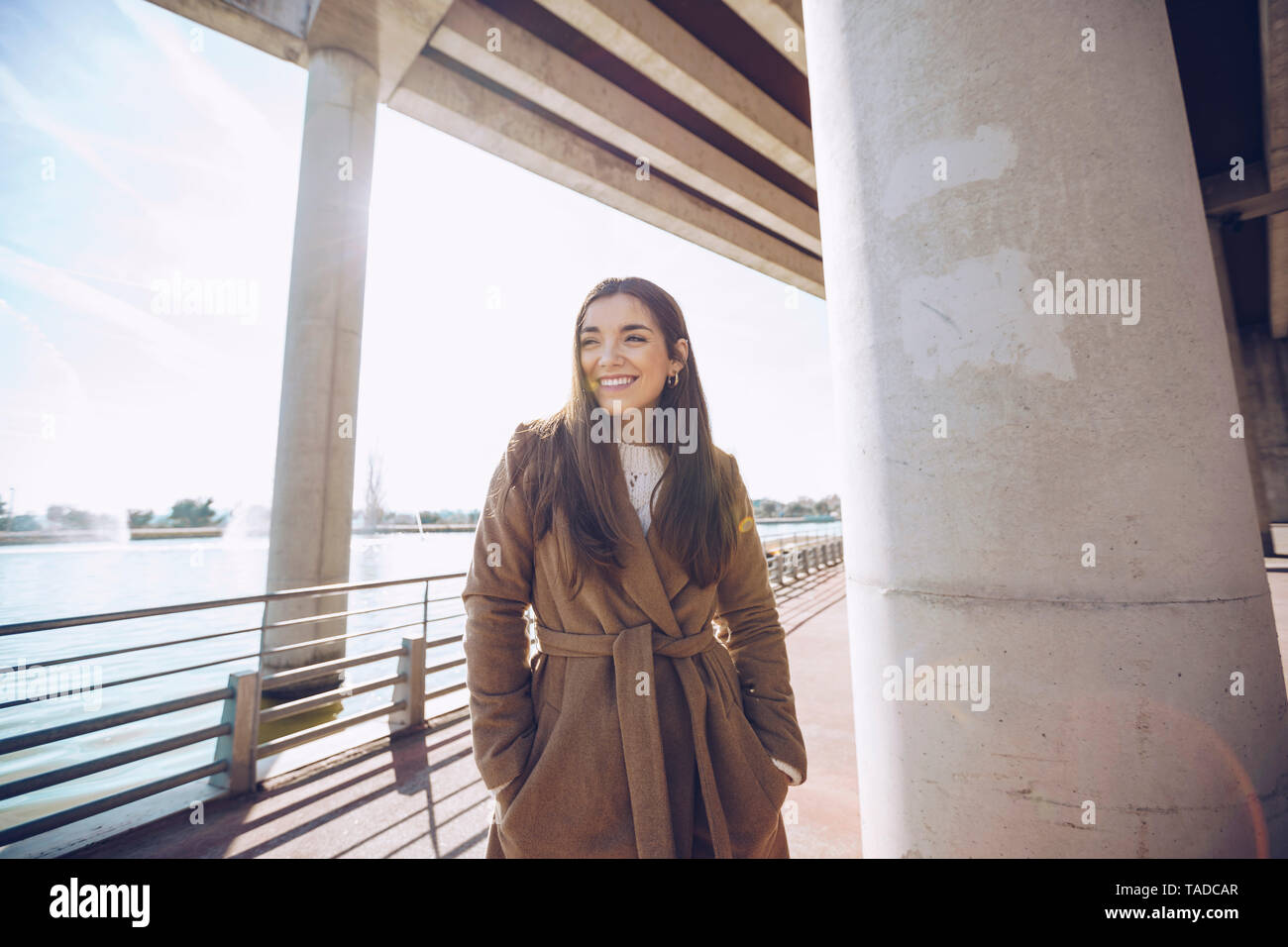 Sorridente giovane donna a un lago Foto Stock