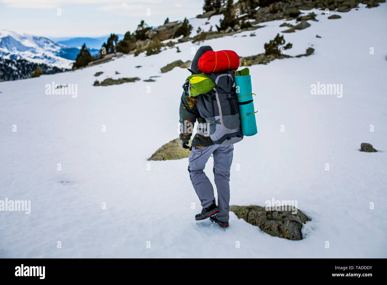 Vista posteriore dell'uomo con zaino, montagne dalle vette innevate Foto Stock