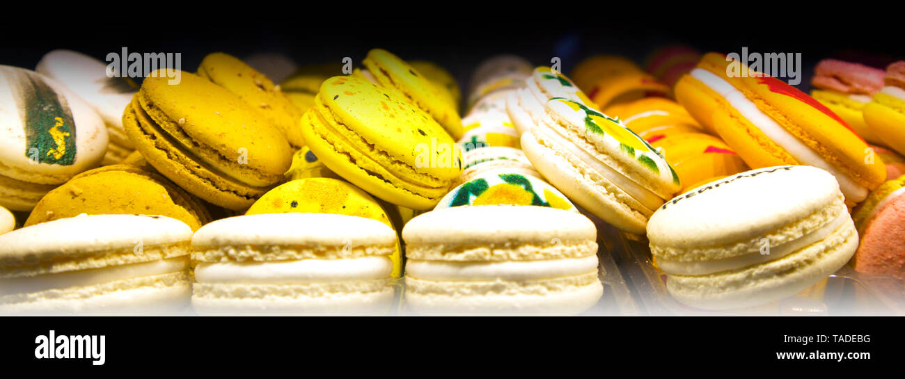 Pile di colorati macarons giacente in un file il caffè in camera, tradizionali biscotti francesi Foto Stock