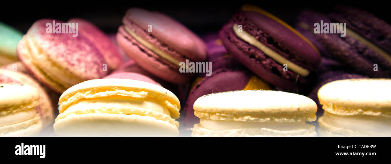 Pile di colorati macarons giacente in un file il caffè in camera, tradizionali biscotti francesi Foto Stock