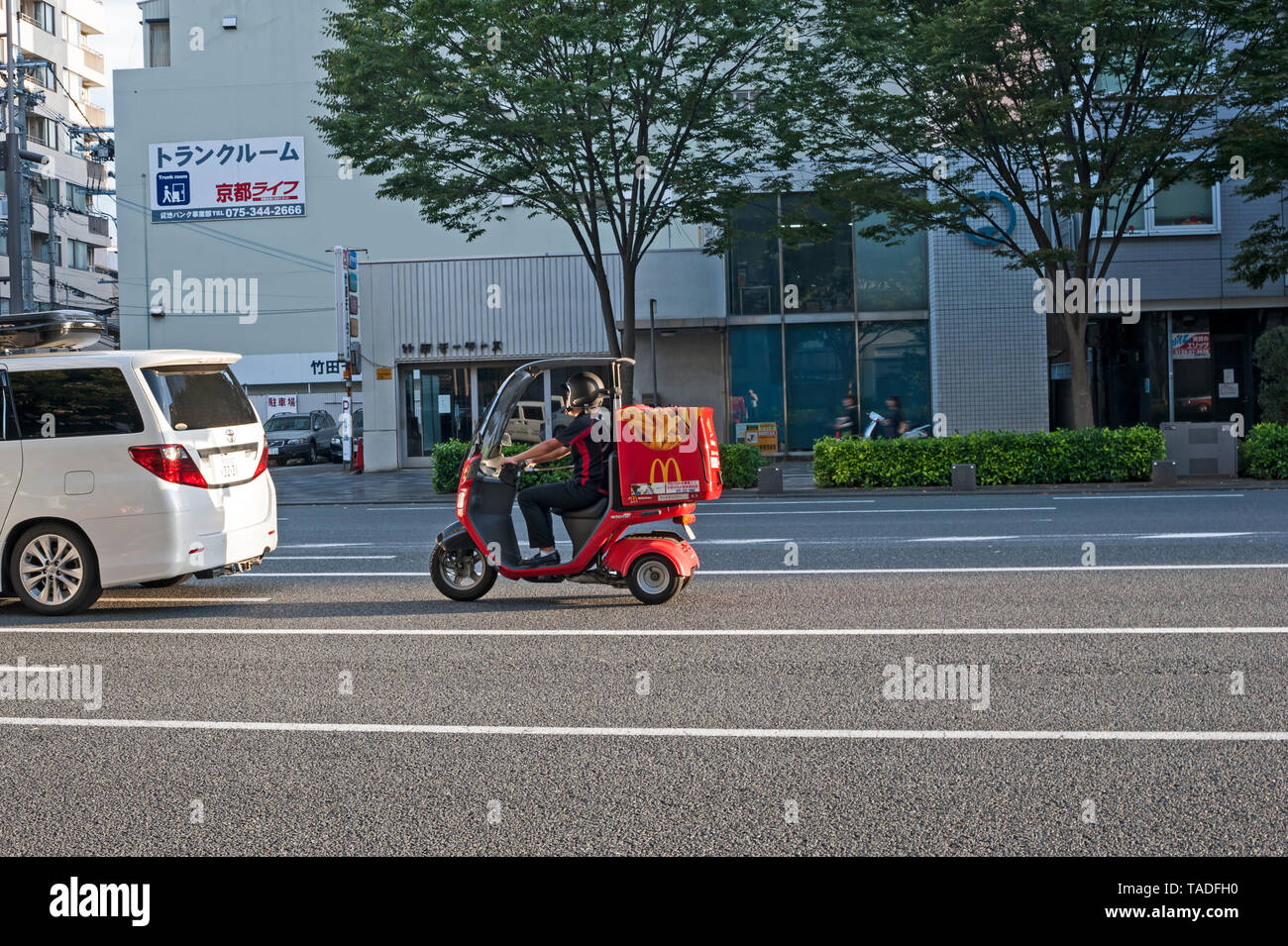 McDonalds driver di consegna su uno scooter rosso su una strada di Tokyo, Giappone. Foto Stock