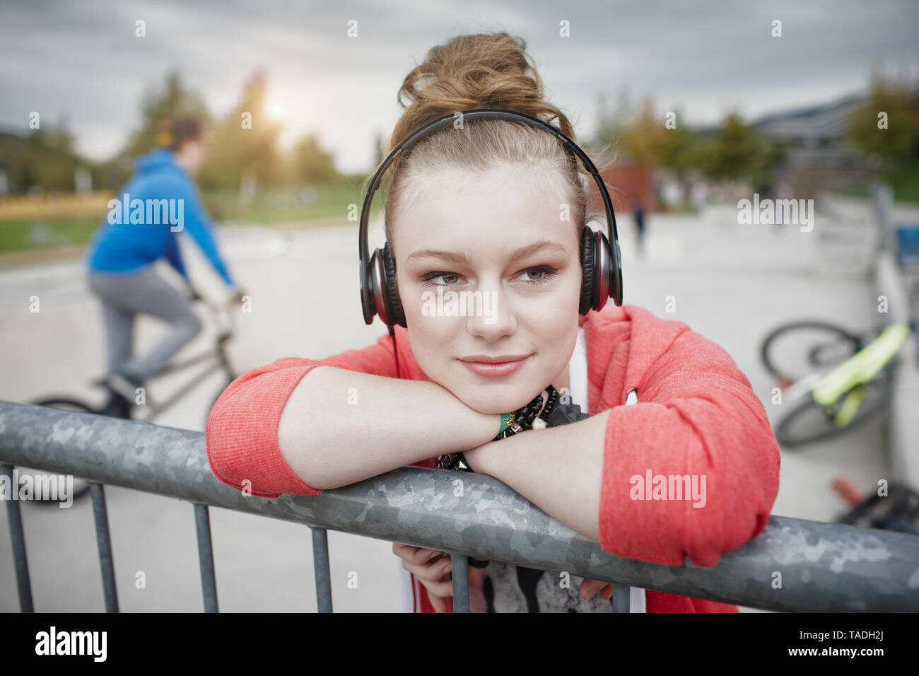 Ritratto di ragazza adolescente che indossano le cuffie a uno skatepark Foto Stock
