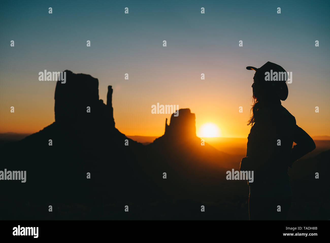 Stati Uniti d'America, Utah, Monument Valley, silhouette di donna con cappello da cowboy guardando sunrise Foto Stock