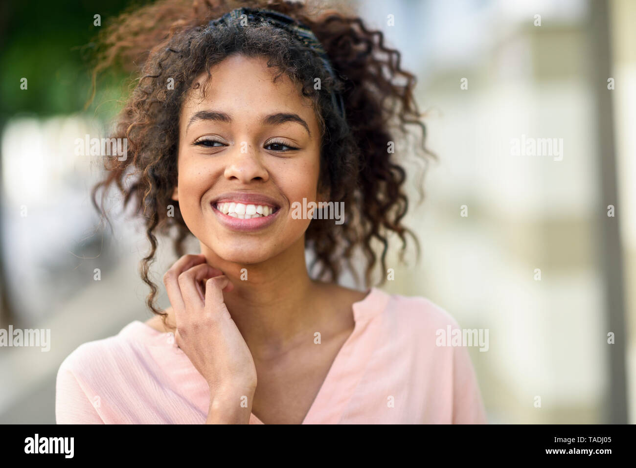 Ritratto di sorridente giovane donna in città Foto Stock