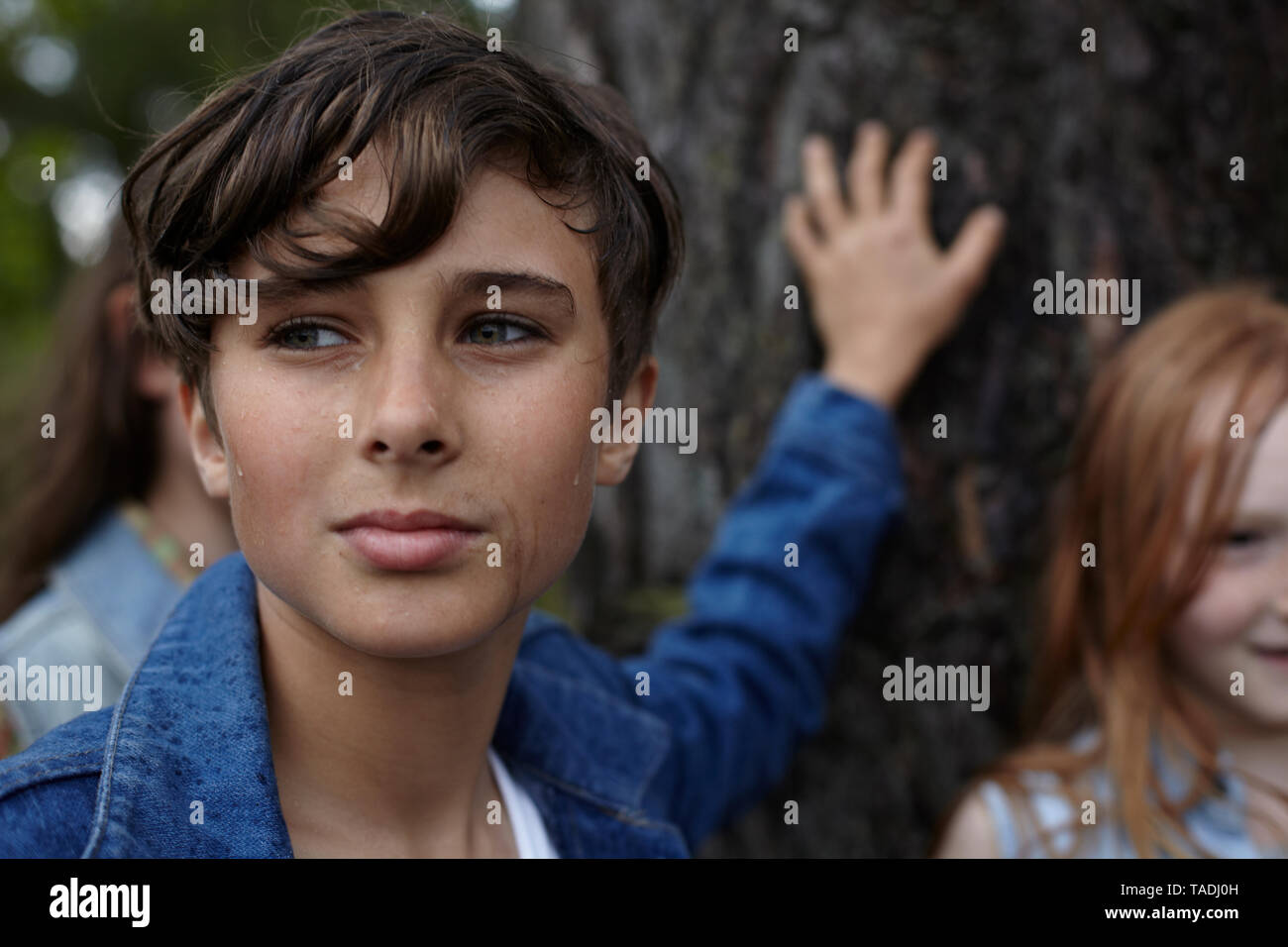 Ritratto di ragazzo con gli amici in una struttura ad albero Foto Stock