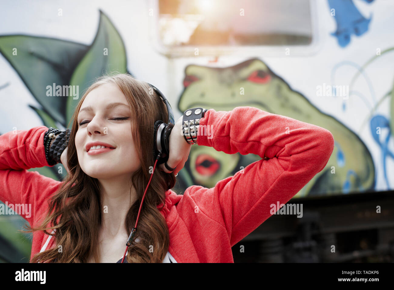 Ritratto di ragazza adolescente che indossano le cuffie a un dipinto di carrozza del treno Foto Stock