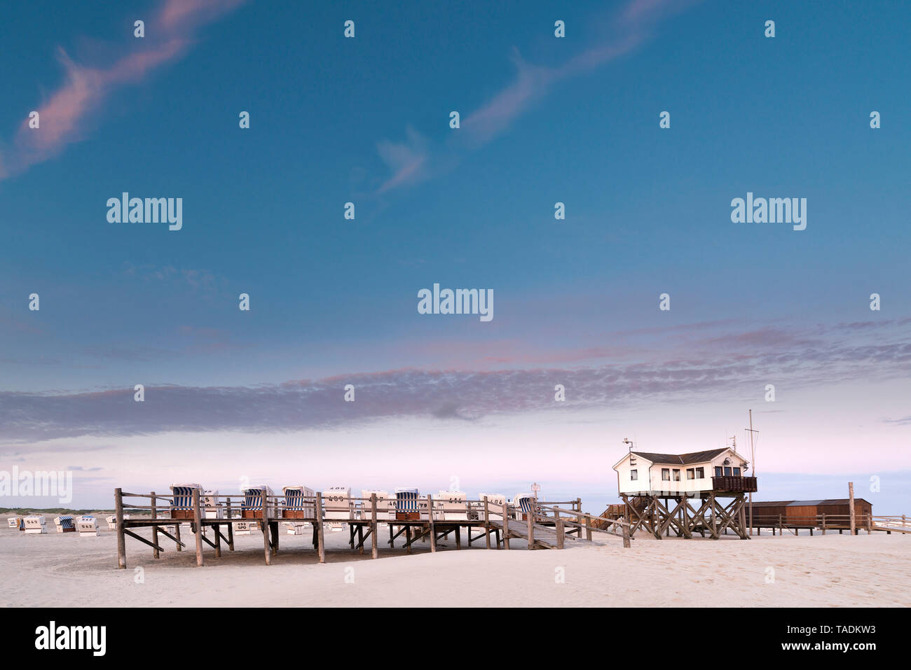 Germania, Sankt Peter Ording, incappucciati sdraio in spiaggia e stazioni palafitticole sulla spiaggia Foto Stock