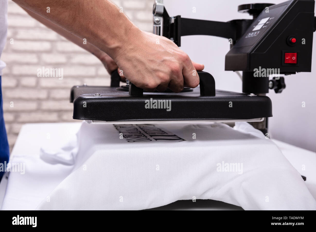 L'uomo stampa su t shirt in officina Foto Stock