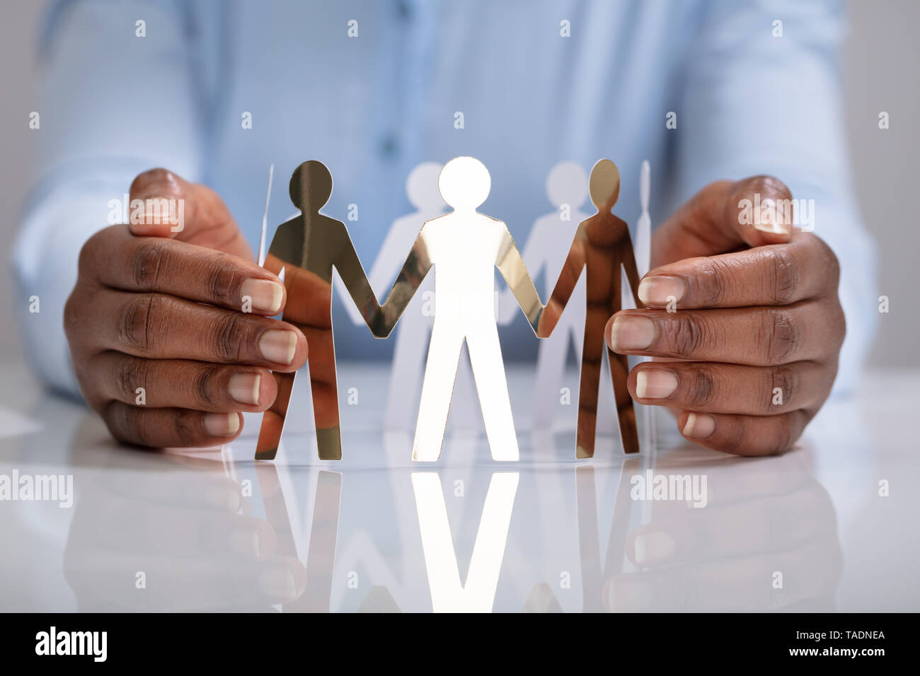 Close-up di mano di una persona la protezione di figure umane cerchio di formatura Foto Stock