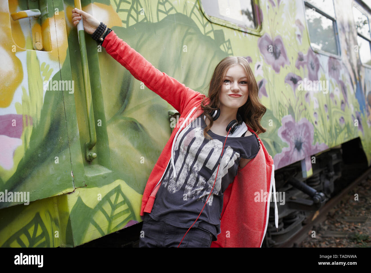 Ritratto di ragazza adolescente smorfie a un dipinto di carrozza del treno Foto Stock