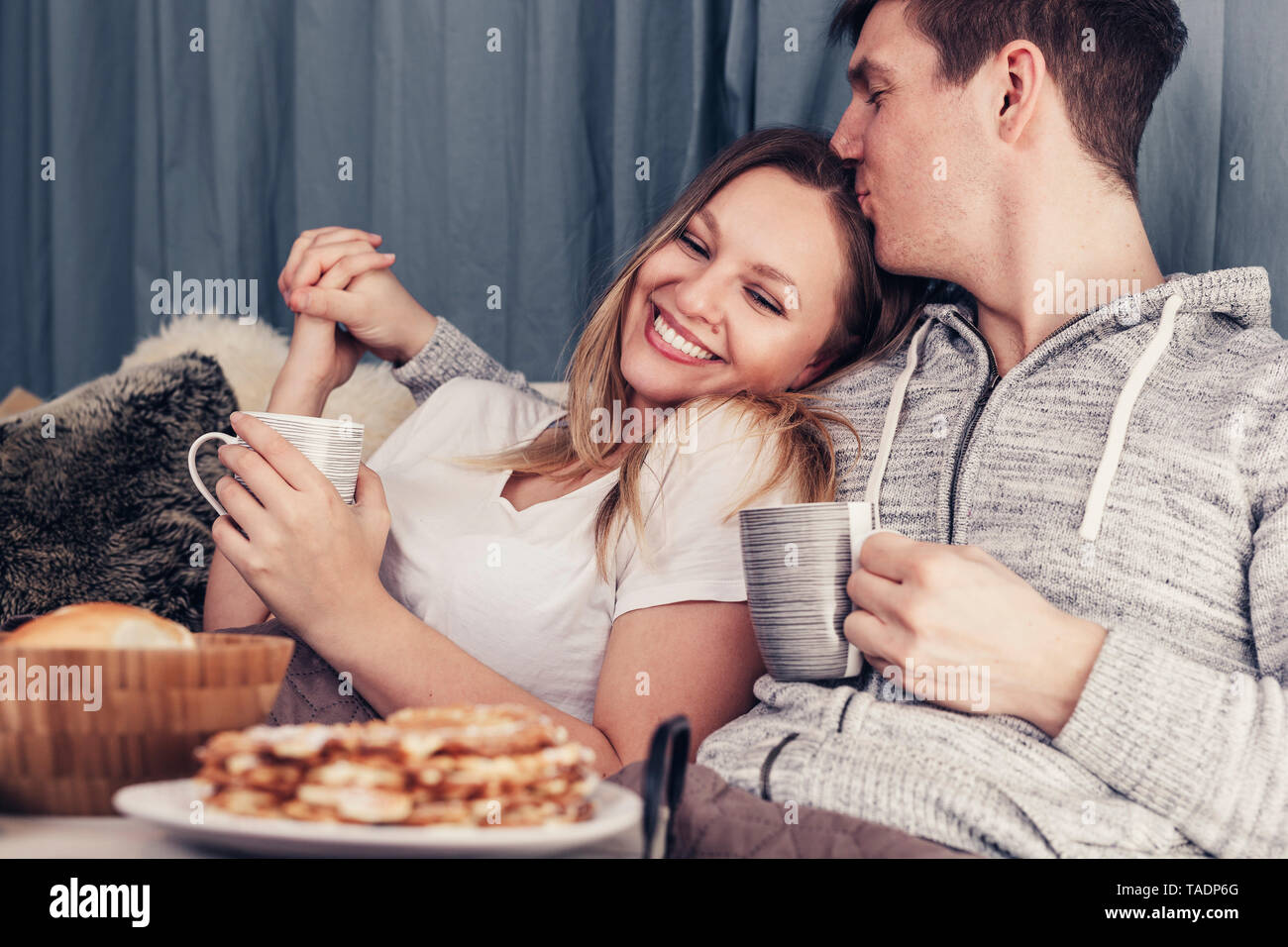 Affettuosa coppia giovane avente la colazione a letto Foto Stock
