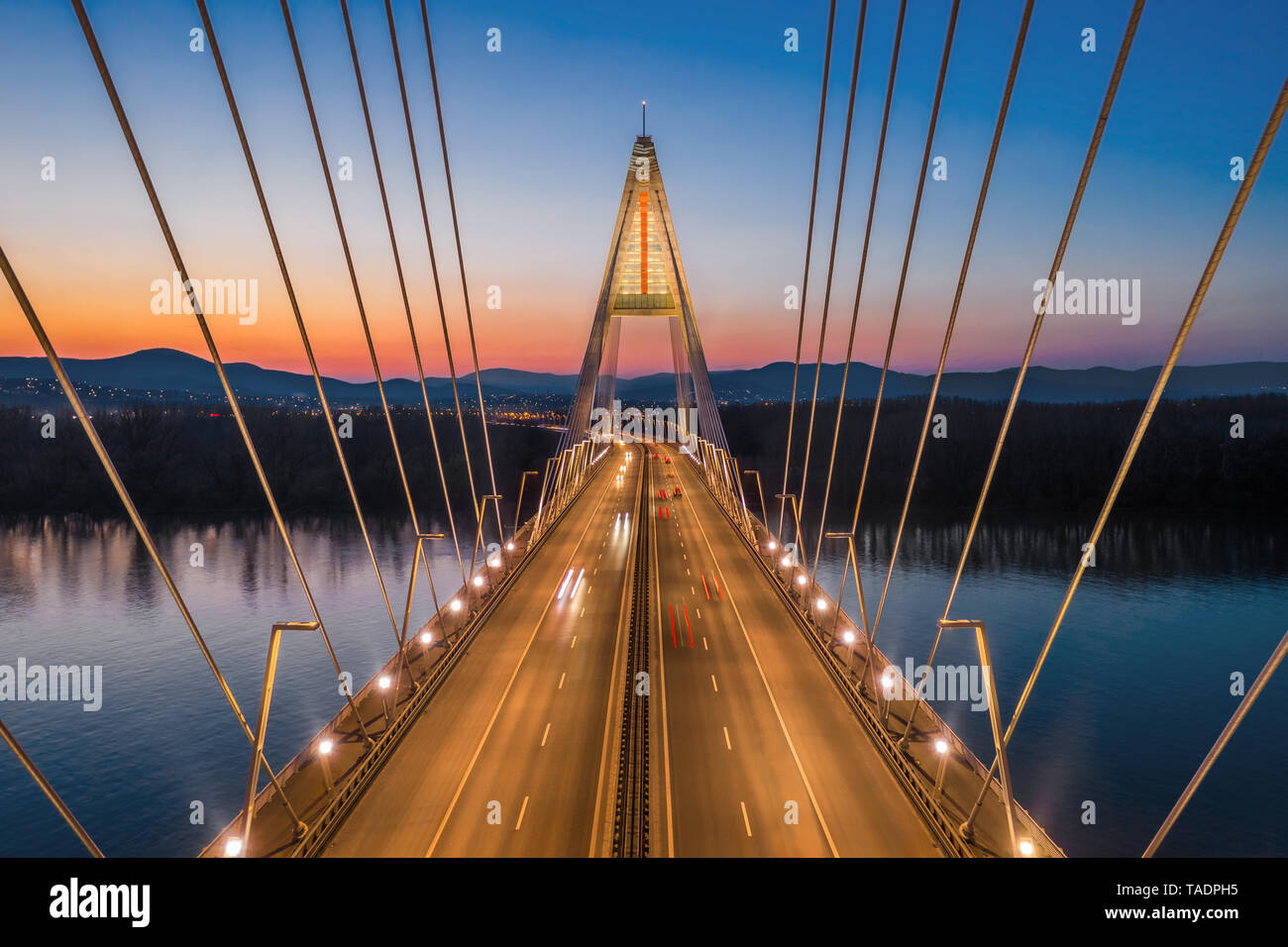 Budapest, Ungheria - Vista aerea della bella cavo-alloggiato Megyeri ponte sul Danubio con il blu e il cielo arancione dopo il tramonto Foto Stock