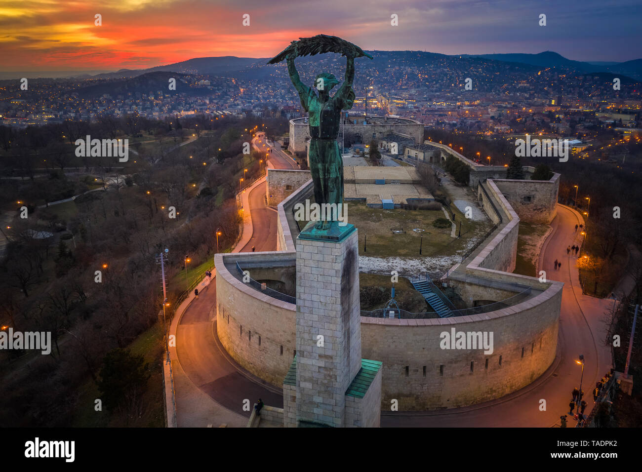 Budapest, Ungheria - Vista aerea ungherese della Statua della Libertà con le colline di Buda e sorprendente colorato tramonto dietro al tempo di inverno Foto Stock