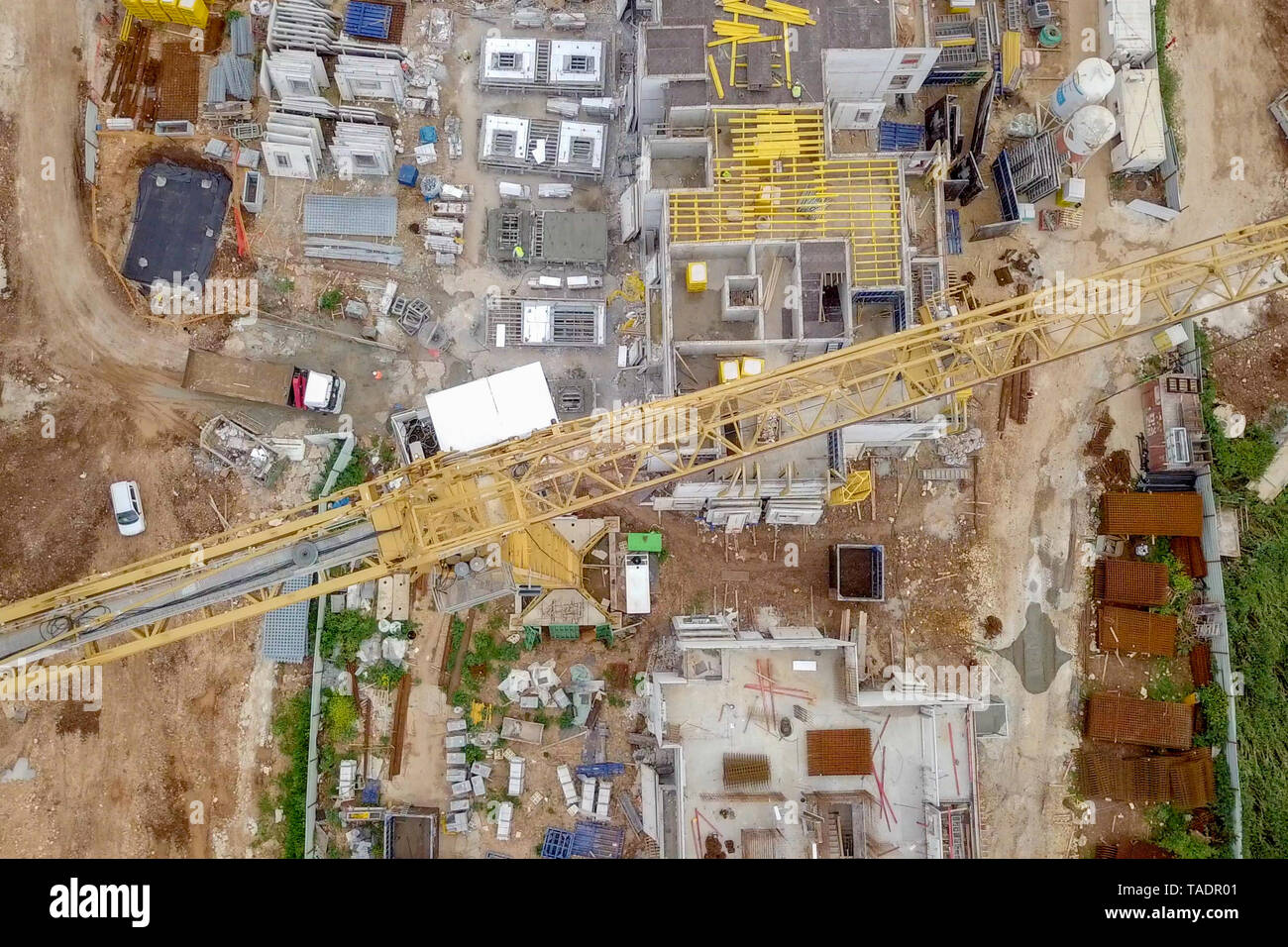 Sito in costruzione - immagine aerea di una grande zona residenziale composto durante le prime fasi di costruzione, con gru e verde ambiente circostante. Foto Stock