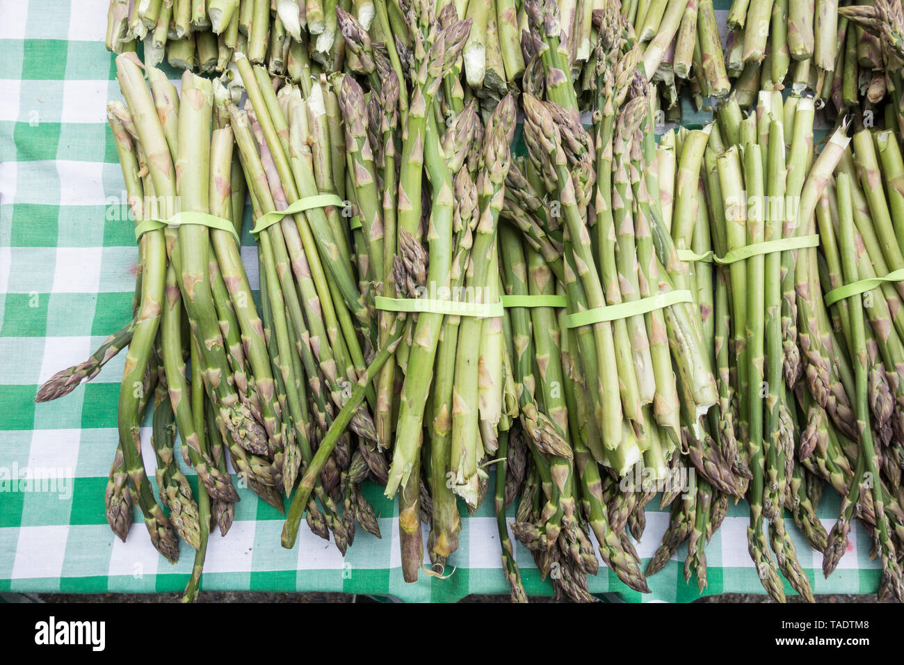 Asparagi in inglese Spears su una verde e bianco tovaglia controllati Foto Stock