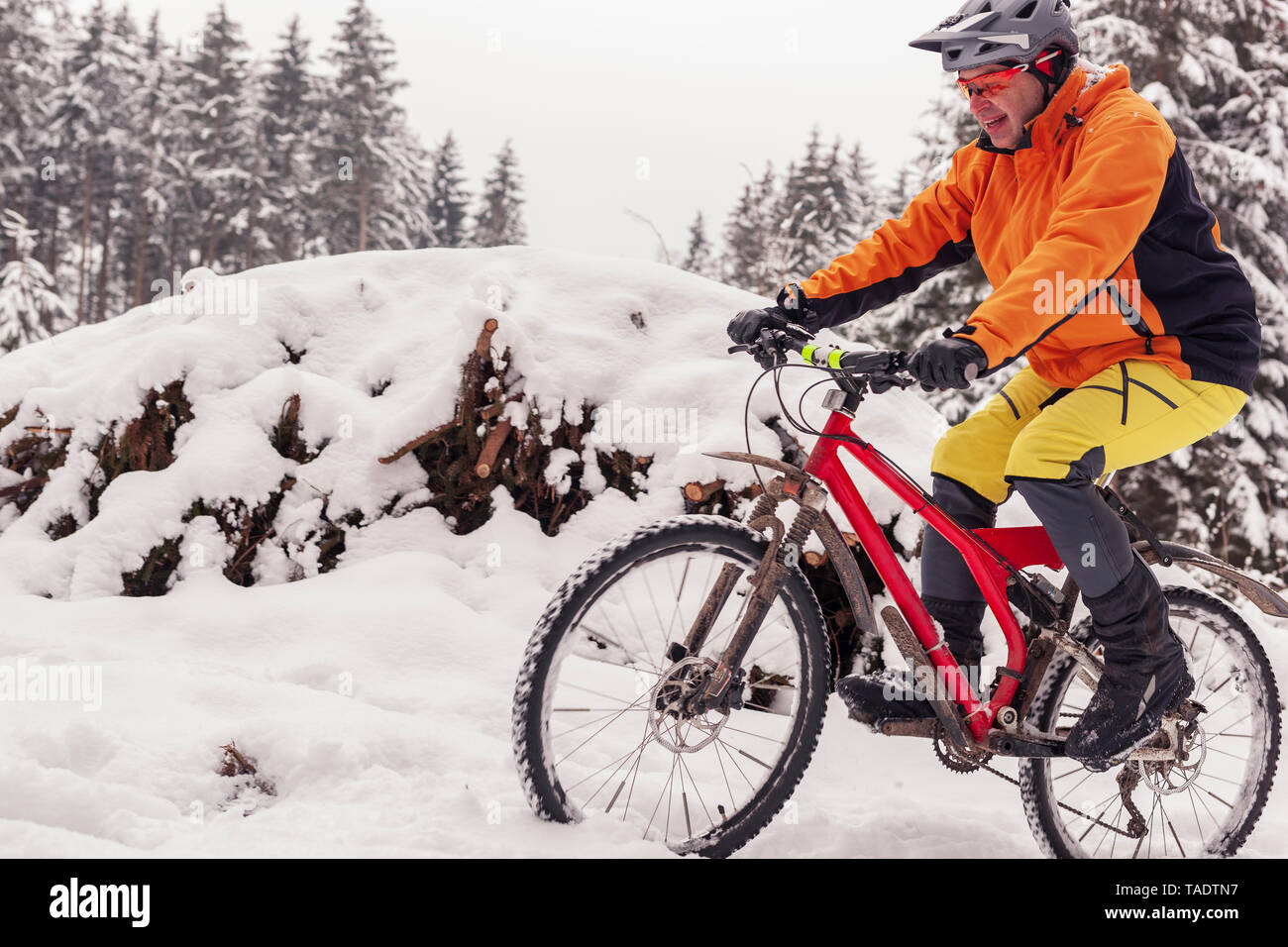 L'uomo equitazione mountain bike sul percorso nella foresta di inverno Foto Stock