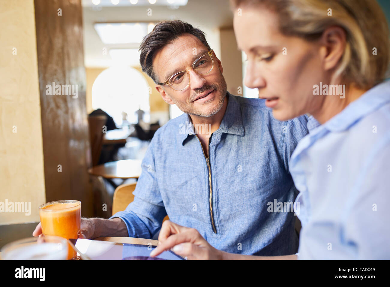 L uomo e la donna con la compressa in un cafe Foto Stock