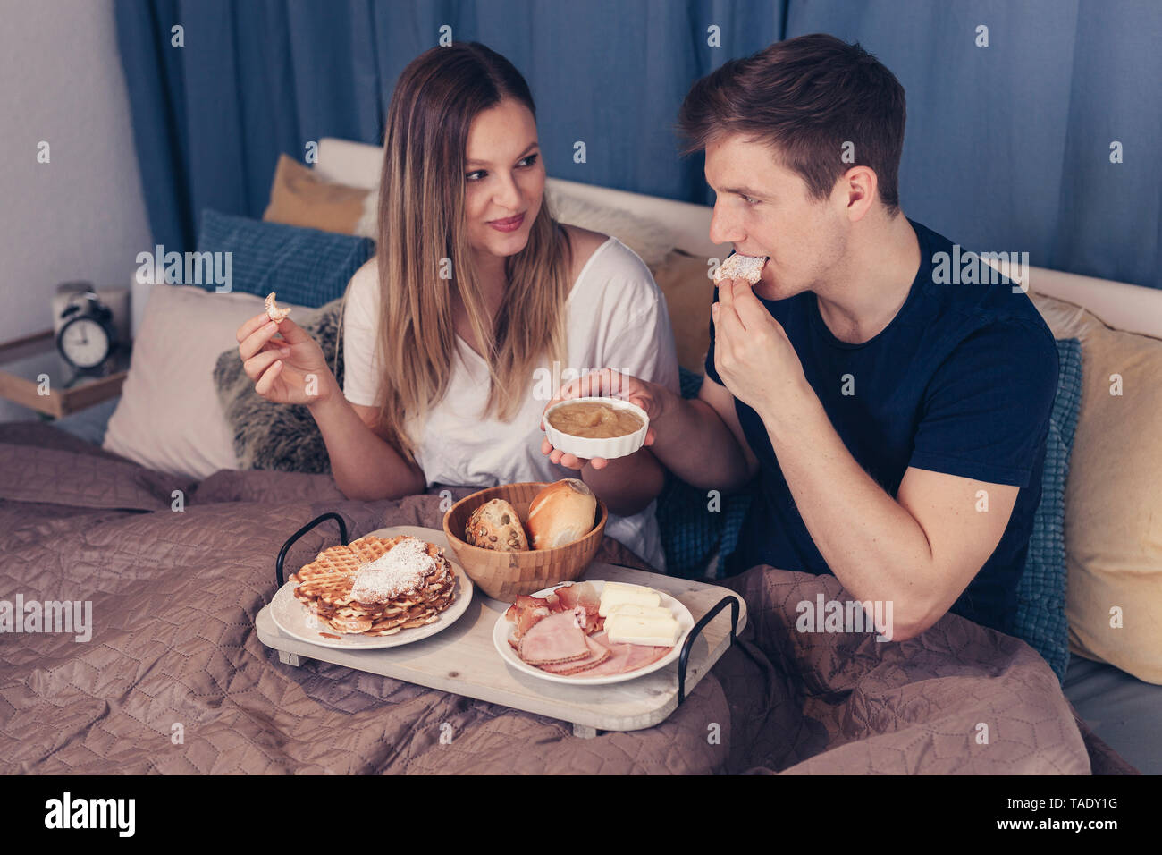 Coppia giovane avente la colazione a letto Foto Stock