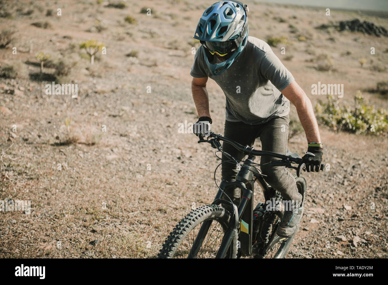 Spagna, Lanzarote, mountainbiker su un viaggio nel paesaggio desertico Foto Stock