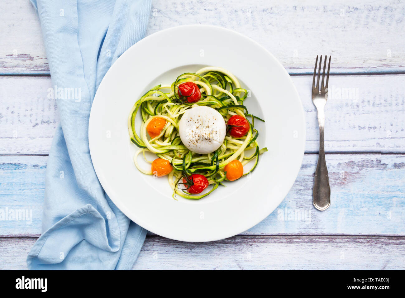 Tagliatelle di zucchine con pomodori al forno, burrata formaggio, pepe e olio di oliva Foto Stock