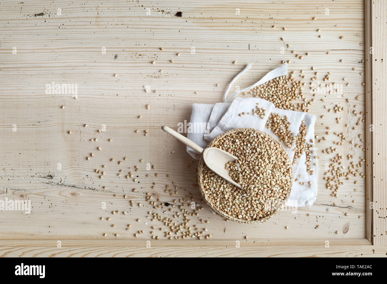 Organici di grano saraceno, grani interi di tiglio ciotola su legno, dal di sopra Foto Stock
