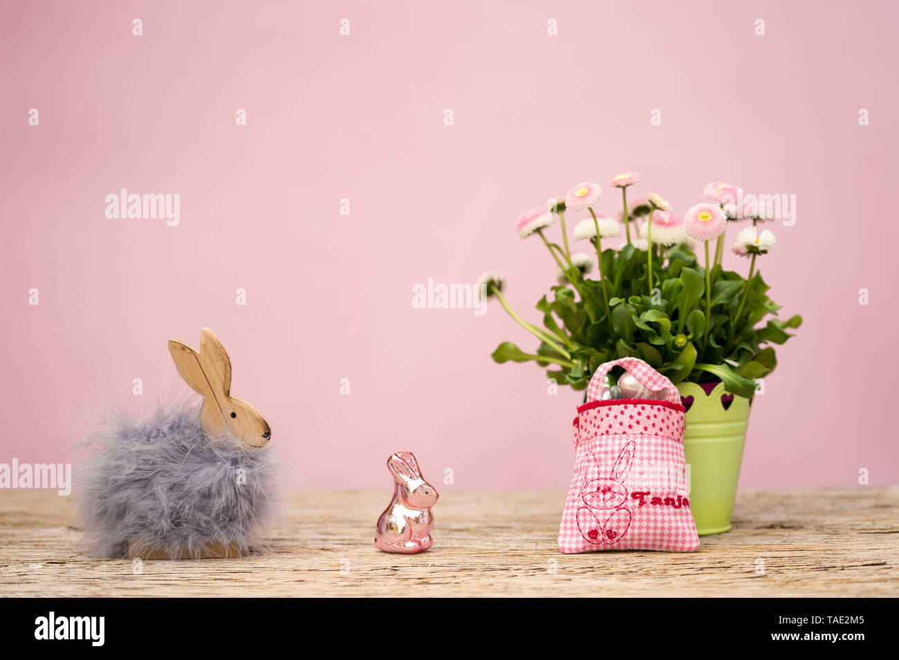 Una piccola borsa con il nome Tanja ricamato è riempito con un piccolo regalo. È la Pasqua, un coniglietto di Pasqua con la pelliccia e un bicchiere di coniglietto di Pasqua in piedi sul Foto Stock