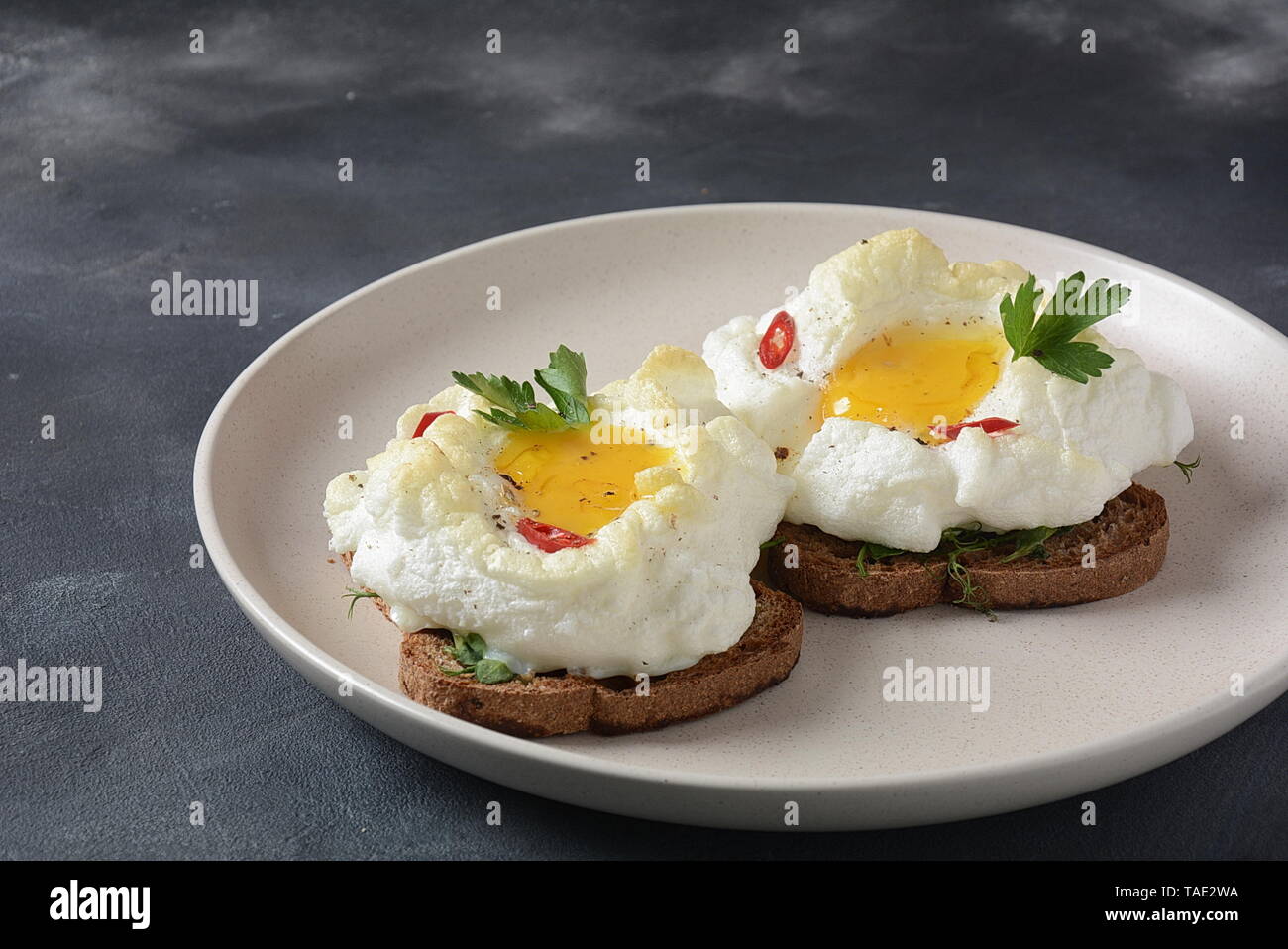 Delicato uovo cotto al forno. Orsini uova nel cloud. Prima colazione francese.Cloud uovo su toast Foto Stock