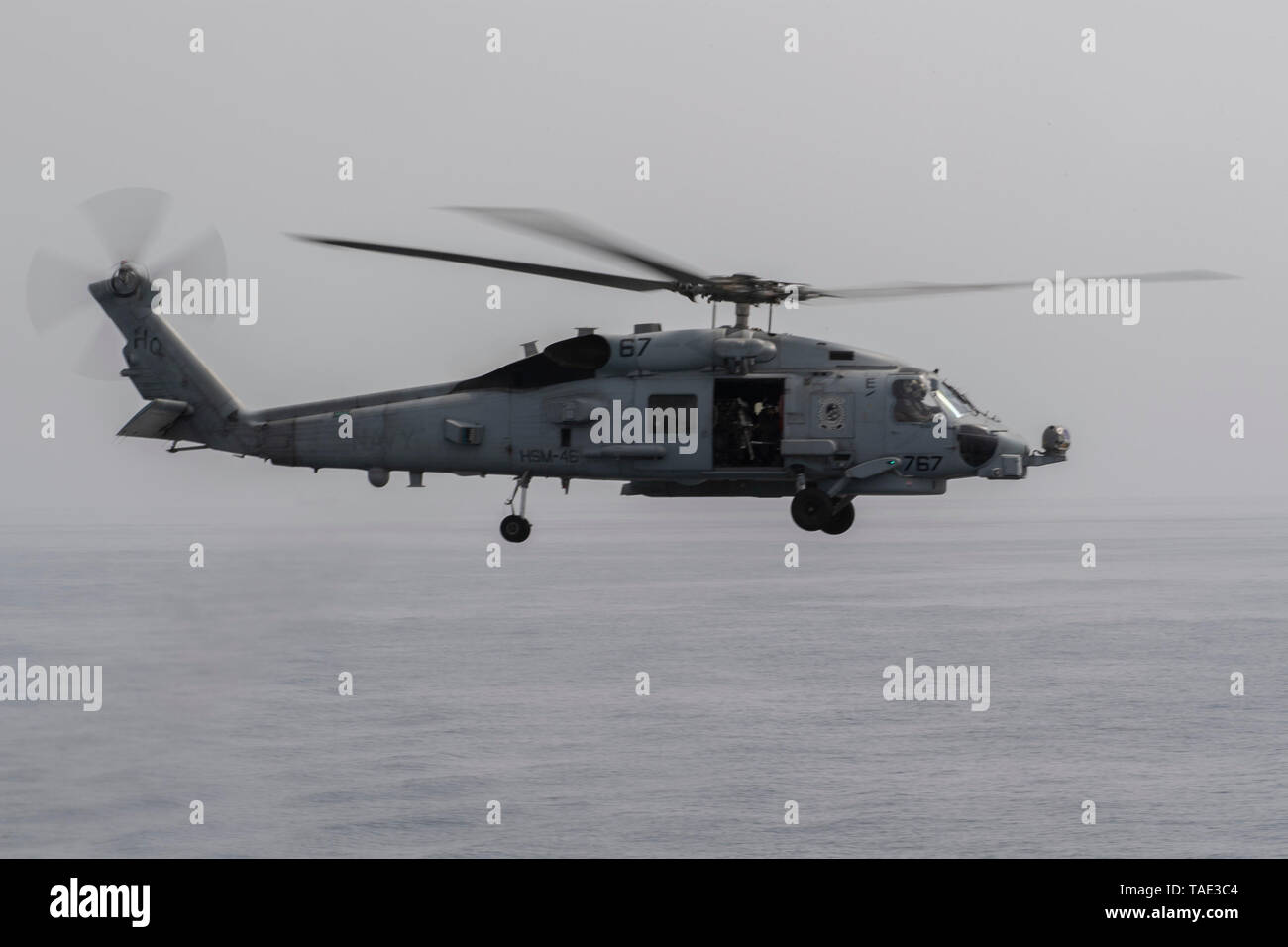 190521-N-XN169-1101 Stretto di Hormuz (21 maggio 2019) un MH-60R Sea Hawk elicottero assegnato al "Granmaestro" di elicottero Maritime Strike Squadron (HSM) 46 le pattuglie vicino al Arleigh Burke-class guidato-missile destroyer USS Mason (DDG 87) mentre in transito attraverso lo Stretto di Hormuz. Mason è in corso come parte di Abramo Lincoln Carrier Strike gruppo, che è pronta a rispondere a contingences e di difendere le forze degli Stati Uniti e degli interessi nella regione. Foto Stock