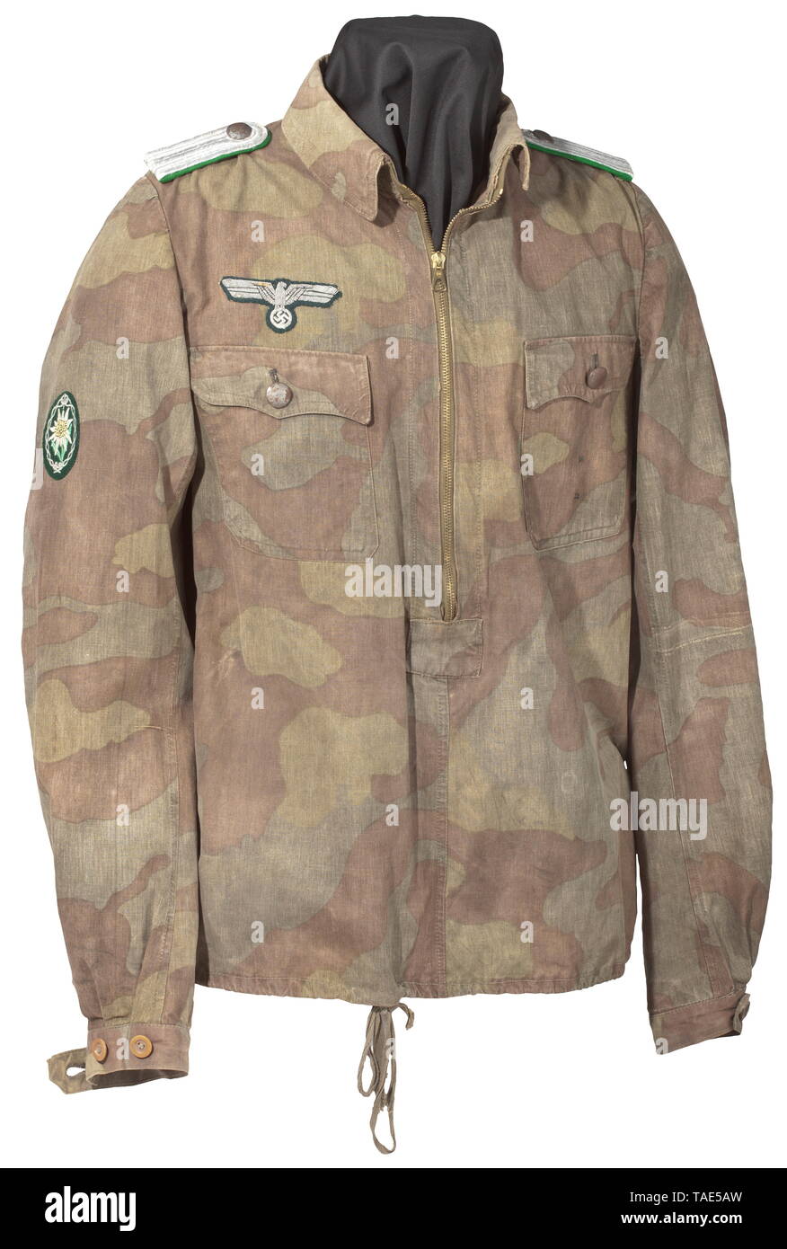 Un camuffamento pullover giacca per un Leutnant delle truppe di montagna professionnelle Feldfertigung aus einseitig bedrucktem, italienischem Zeltplanenstoff. Mittig ein zu 2/3 durchgehender Reißverschluss, einfacher Kragen, zwei aufgesetzte Brusttaschen mit Verschlussklappen, der untere Abschluss mit eingearbeiteter Zugschnur, die Ärmelenden durch Knöpfe verstellbar. Silberngestickter Brustadler, maschinengesticktes Ärmeledelweiß, aufgeschlaufte Schulterklappen. storica, storica, esercito, eserciti, forze armate, militare, militaria, oggetto, oggetti, alambicchi, clipping, ritagli, tagliare o, Editorial-Use-solo Foto Stock