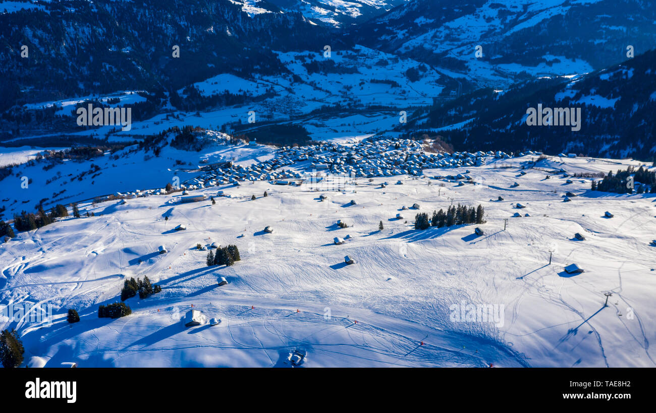 Vista aerea di un villaggio in inverno in Svizzera Laax. Paesaggio invernale. Sole splendente. Il concetto di libertà e di solitudine Foto Stock