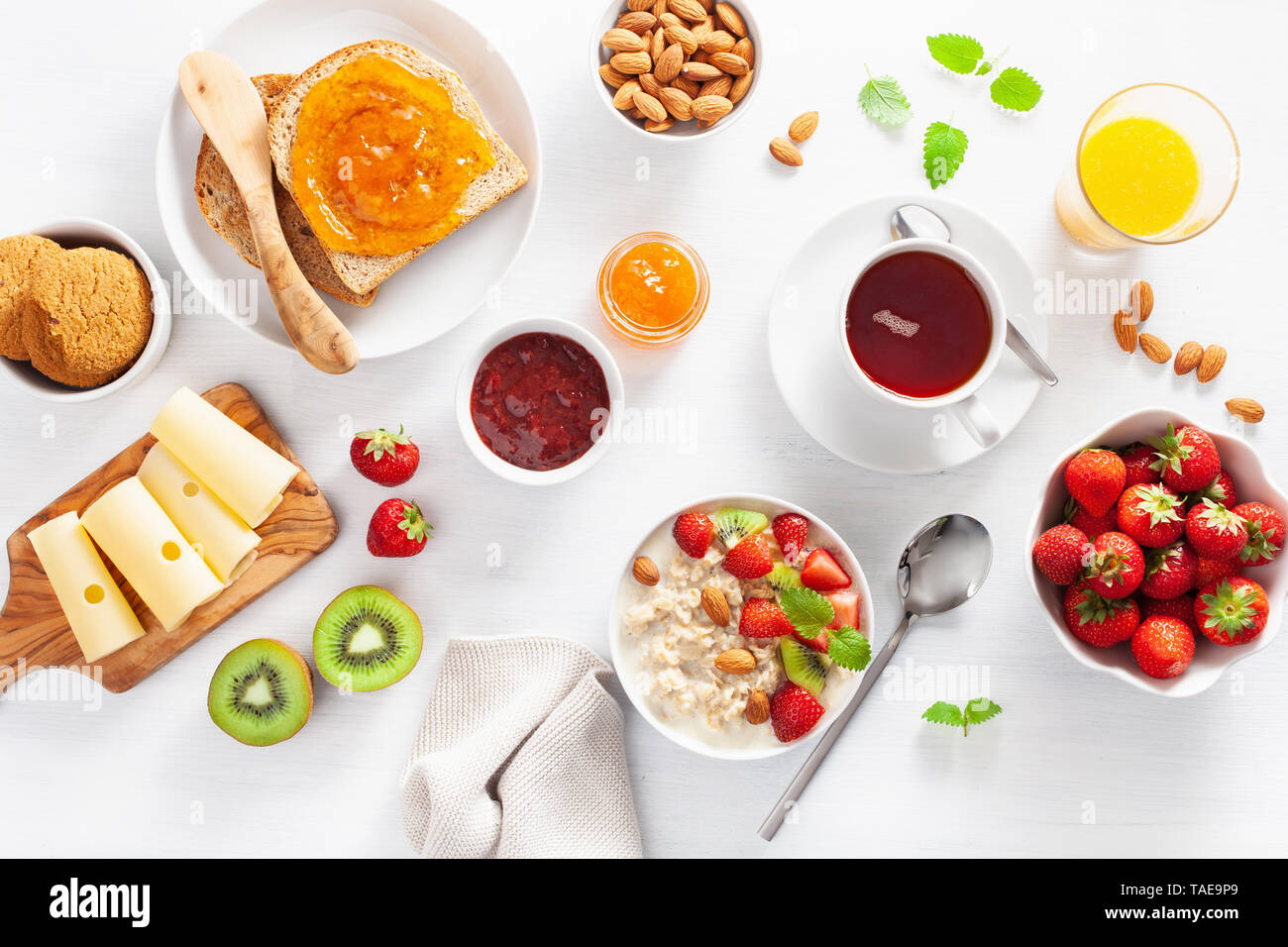 Sana colazione con i fiocchi d'avena porridge, fragola, dadi, toast, marmellata e tè. Vista superiore Foto Stock