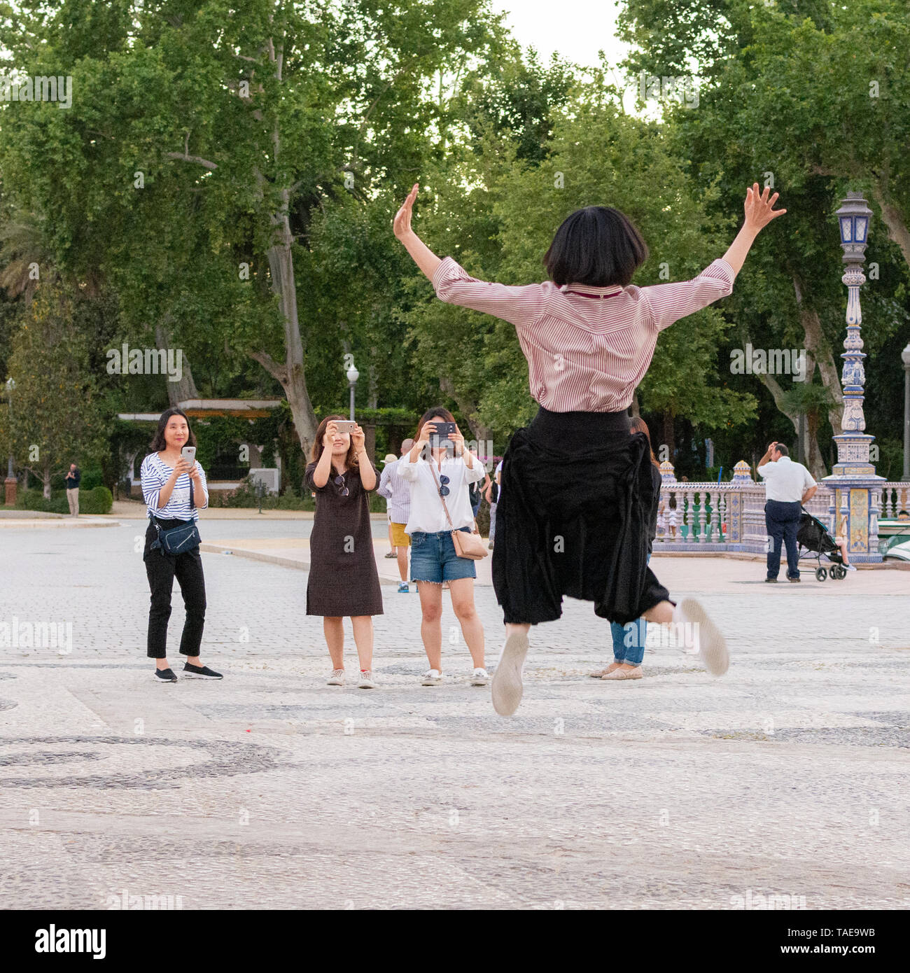 Turista giapponese di impegno creativo nella fotografia di viaggio da saltare in aria di fronte una attrazione turistica. Foto Stock