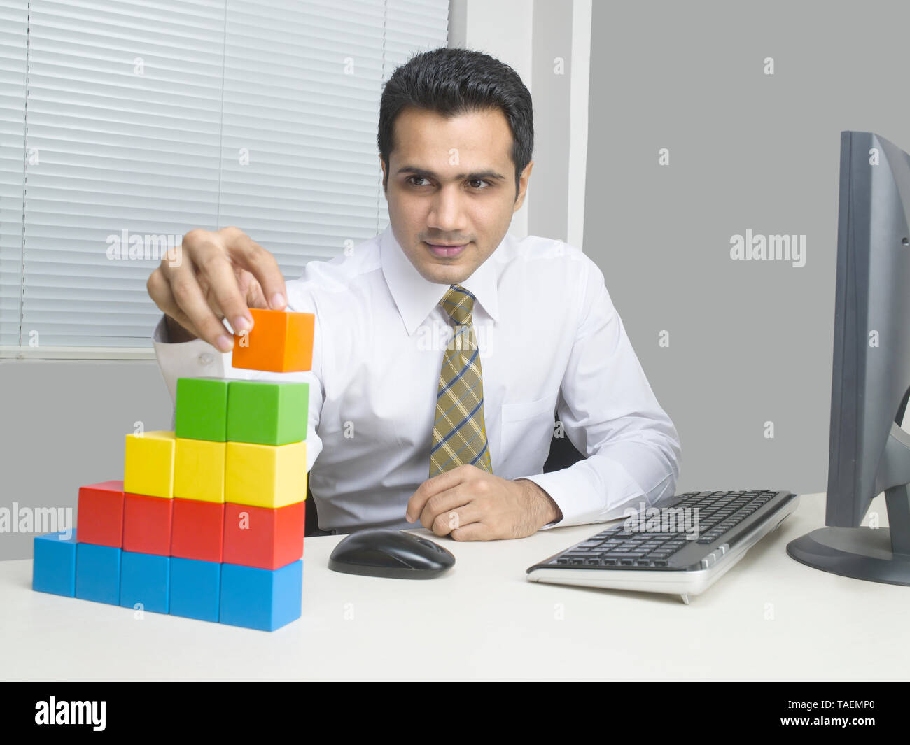 I dirigenti aziendali utilizzando blocchi di costruzione per costruire un edificio concettuale Foto Stock
