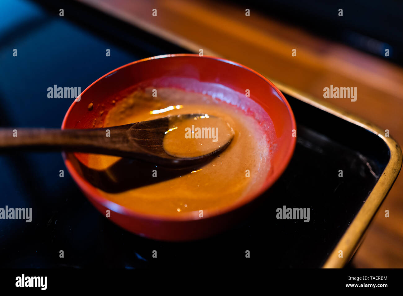 Tradizionale Giapponese del vaso in ristorante con nero laccato legno sfondo tabella e salsa di miso e cucchiaio Foto Stock