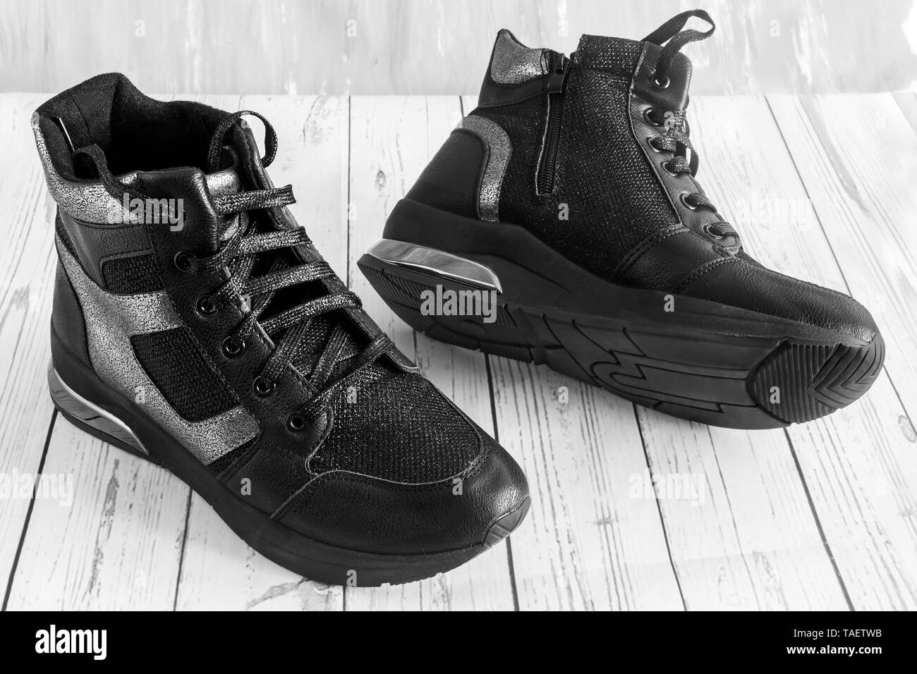 Confortevole sneakers nero con pannelli grigio su una piattaforma elevata con una cerniera lampo e lace-up. Immagine in bianco e nero Foto Stock