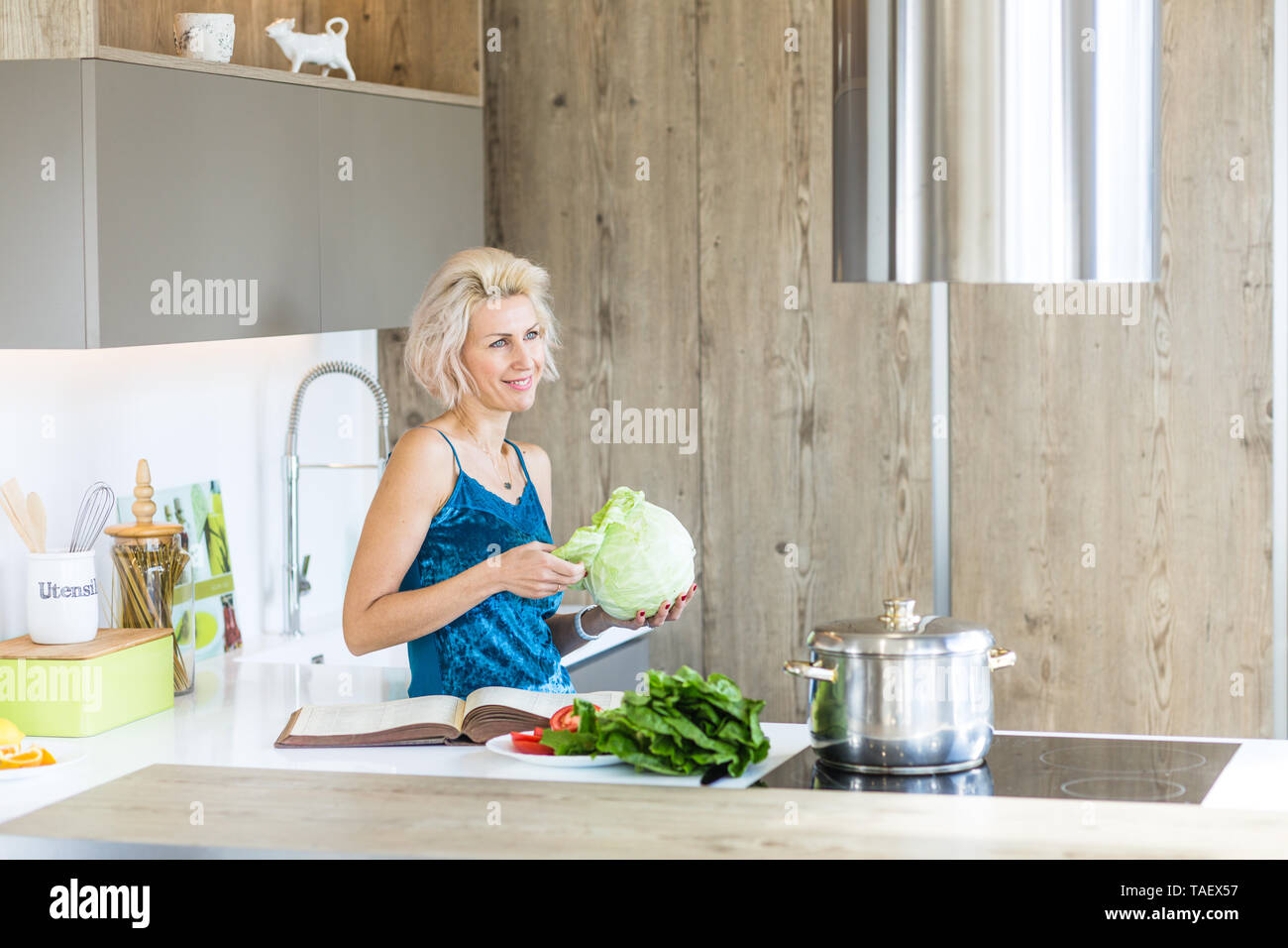 Giovane donna bionda la cottura nella cucina moderna Foto Stock