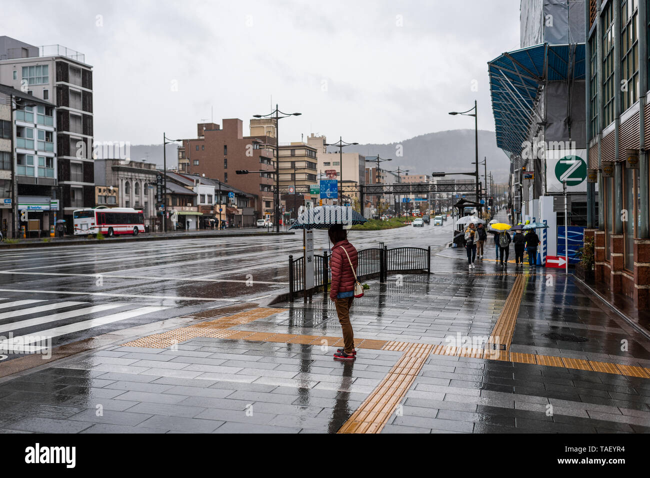 Kyoto, Giappone - Aprile 9, 2019: Gojo-dori street vicino al quartiere di Gion durante il piovoso nuvoloso giorno e persona con ombrello sul marciapiede Foto Stock