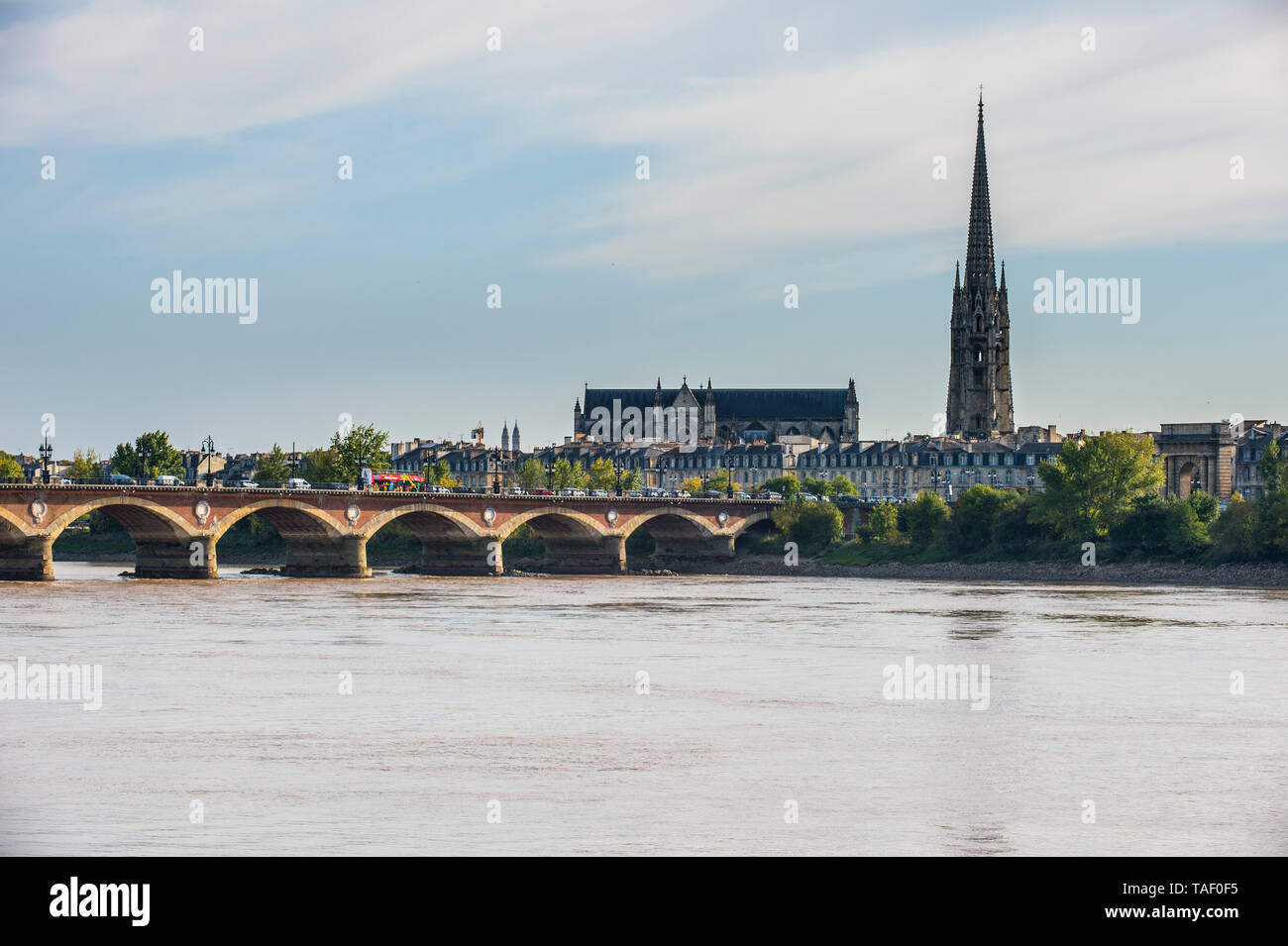 Francia, Bordeaux, Pont de Pierre ponte con il Basiclica San Michele in background Foto Stock