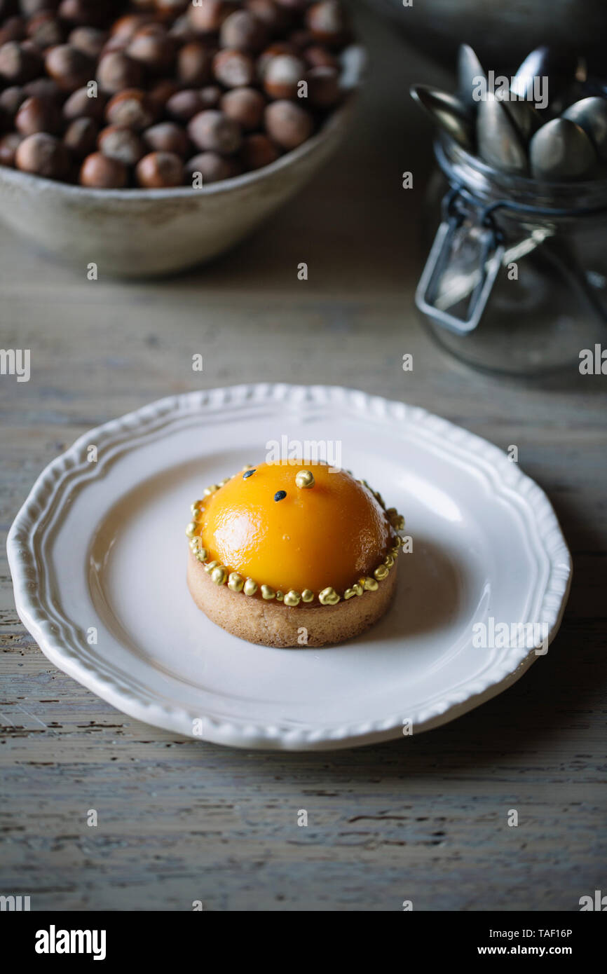 Decorate con tarlet peach metà su piastra Foto Stock