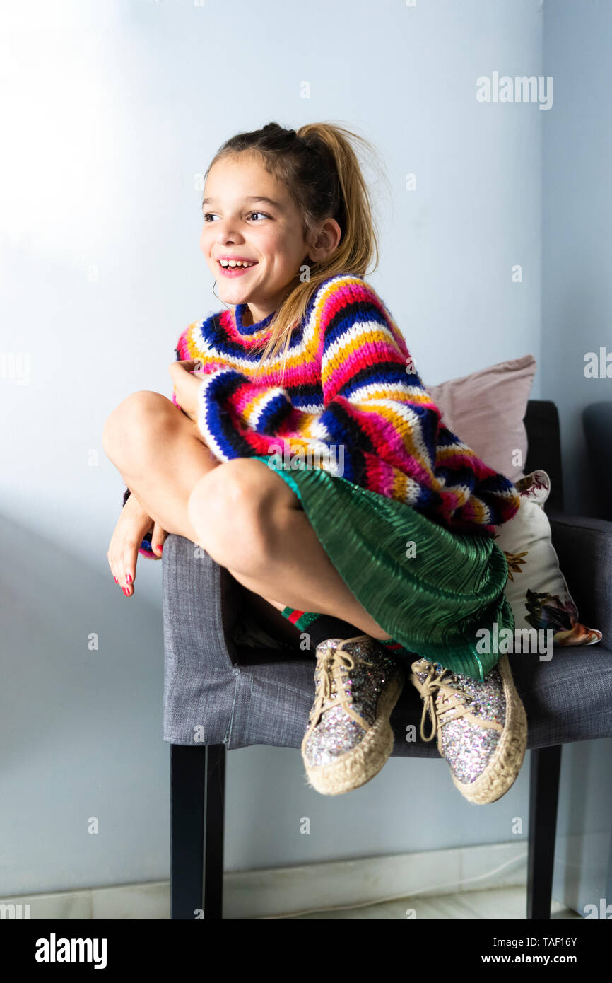 Felice ragazza in striped pullover seduti su una sedia a casa Foto stock -  Alamy