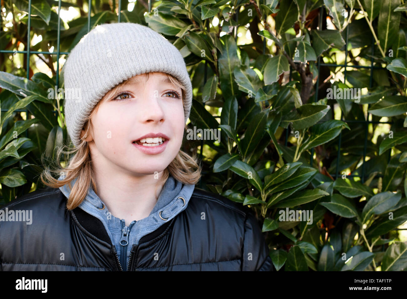 Ritratto di ragazzo indossa wooly hat a una siepe Foto Stock