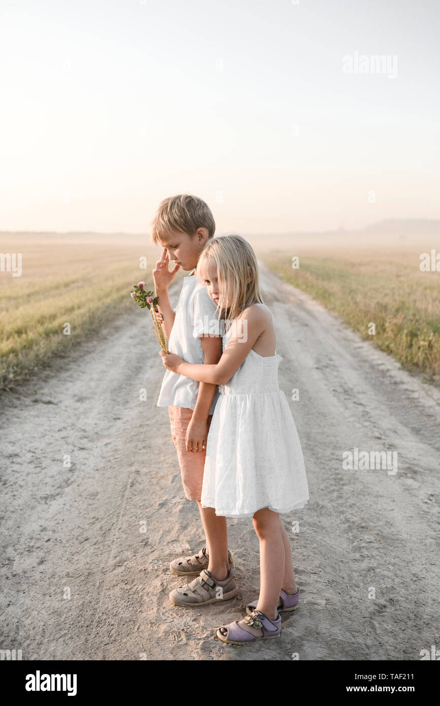 Abbracciando la ragazza ragazzo su una rurale traccia di sporco Foto Stock