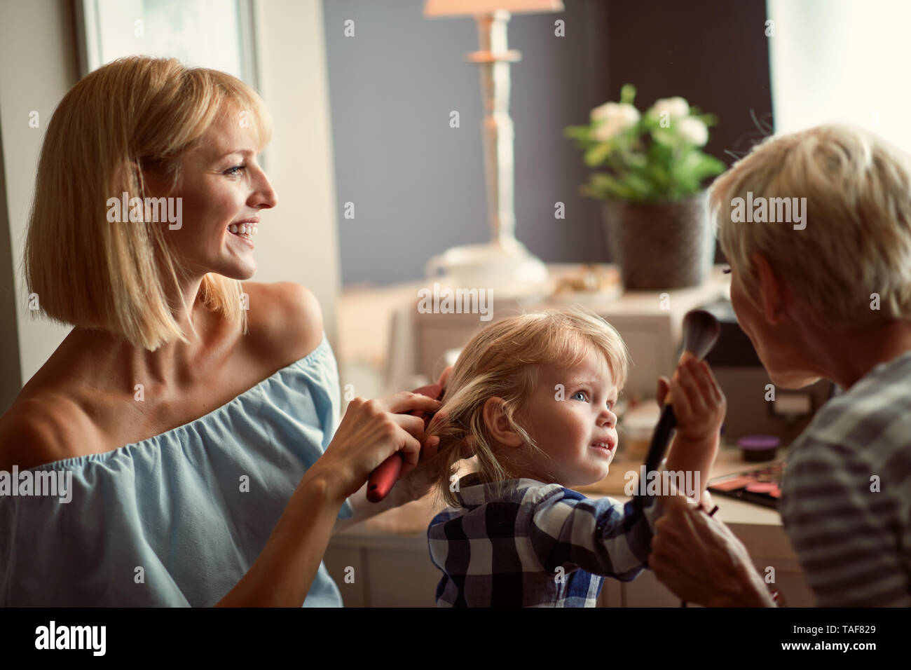 Ragazza carina con la madre e la nonna abbellisce e divertirsi Foto Stock