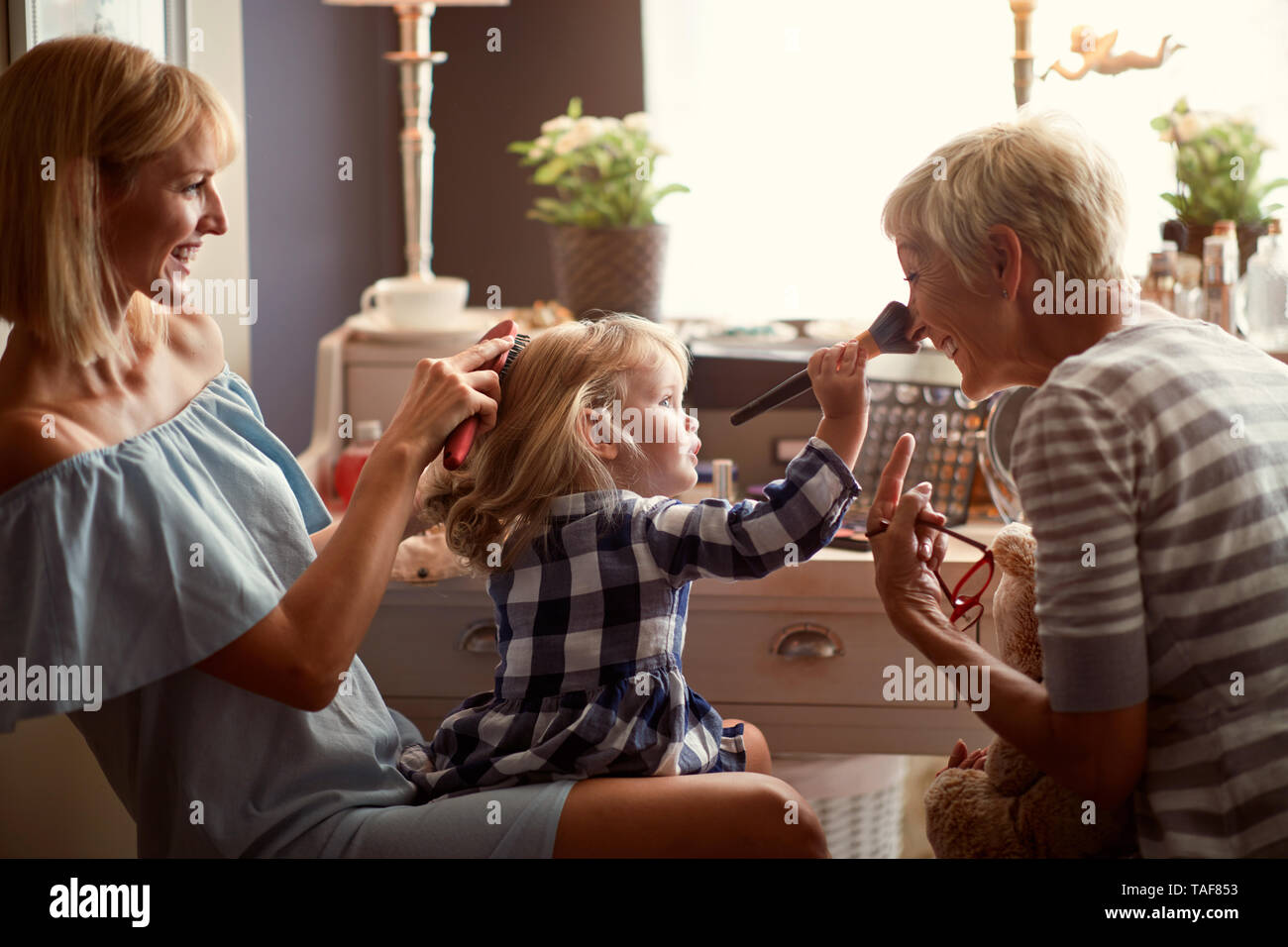 Bambino con la mamma in visita alla nonna giocare e divertirsi Foto Stock