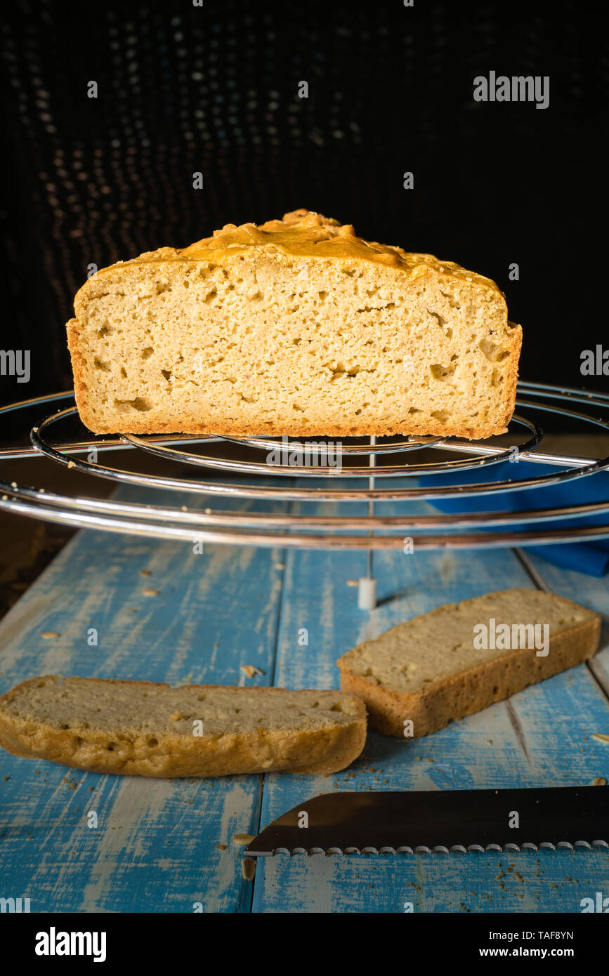 Fette di fatti in casa il pane di mais su un blu tavolo di legno e su di un acciaio inossidabile grill Foto Stock