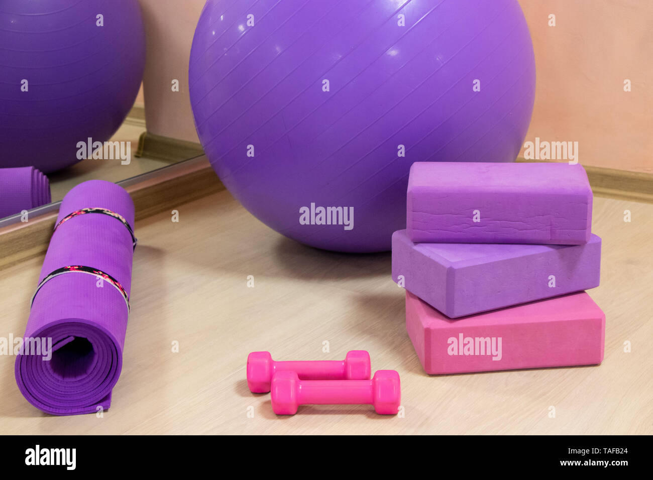 Attrezzi Fitness - sfera, rosa e viola cubi e manubri, viola mat, sport concetto,la foto in orizzontale Foto Stock