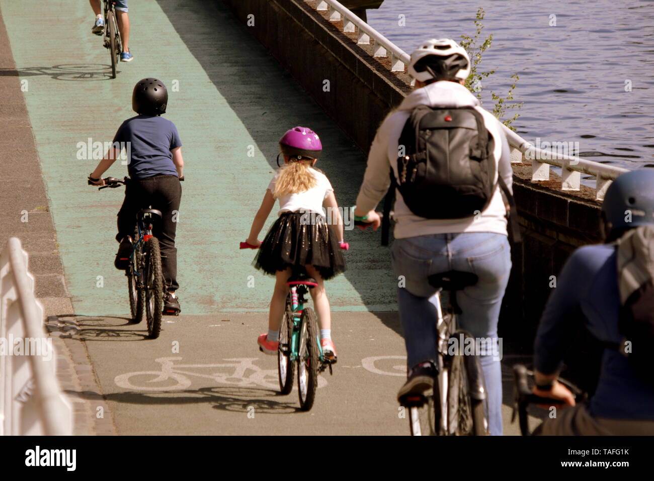 Glasgow, Scotland, Regno Unito XXIV Maggio, 2019. Regno Unito Meteo: giornata di sole ha visto la gente del posto fuori a godersi il tempo nelle strade della città come persone hanno svolto sulle aree verdi del Clyde marciapiede accanto al fiume Clyde. Gerard Ferry/Alamy Live News Foto Stock
