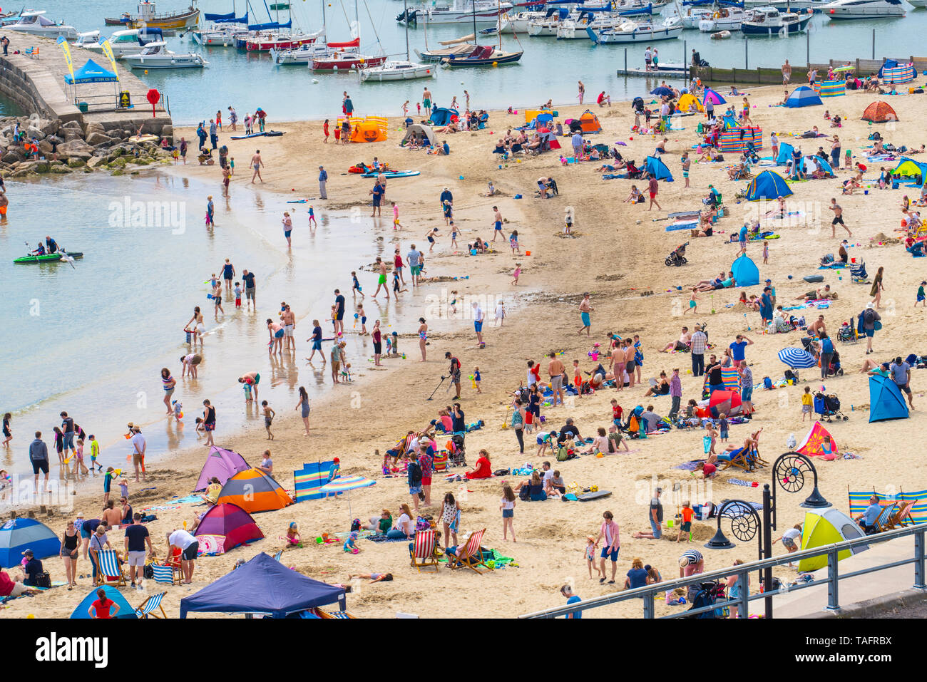 Lyme Regis, Dorset, Regno Unito. 25 maggio 2019. Meteo REGNO UNITO: folle di turisti e visitatori accorrono per la spiaggia di Lyme Regis a crogiolarvi al sole caldo come il resort costiero sfrigola su il giorno più caldo dell'anno finora. Il sabato è impostata in modo da essere il più soleggiato giorno di fine maggio weekend festivo. Credito: Celia McMahon/Alamy Live News. Credito: Celia McMahon/Alamy Live News Foto Stock