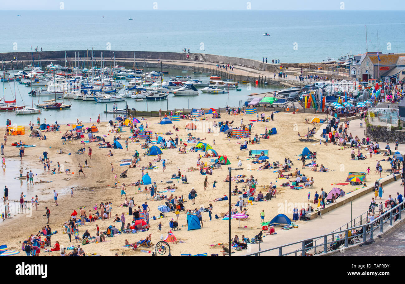 Lyme Regis, Dorset, Regno Unito. 25 maggio 2019. Meteo REGNO UNITO: folle di turisti e visitatori accorrono per la spiaggia di Lyme Regis a crogiolarvi al sole caldo come il resort costiero sfrigola su il giorno più caldo dell'anno finora. Il sabato è impostata in modo da essere il più soleggiato giorno di fine maggio weekend festivo. Credito: Celia McMahon/Alamy Live News. Credito: Celia McMahon/Alamy Live News Foto Stock