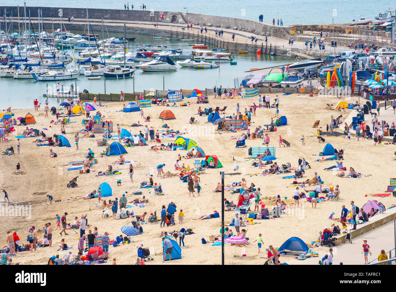 Lyme Regis, Dorset, Regno Unito. 25 maggio 2019. Meteo REGNO UNITO: folle di turisti e visitatori accorrono per la spiaggia di Lyme Regis a crogiolarvi al sole caldo come il resort costiero sfrigola su il giorno più caldo dell'anno finora. Il sabato è impostata in modo da essere il più soleggiato giorno di fine maggio weekend festivo. Credito: Celia McMahon/Alamy Live News. Credito: Celia McMahon/Alamy Live News Foto Stock